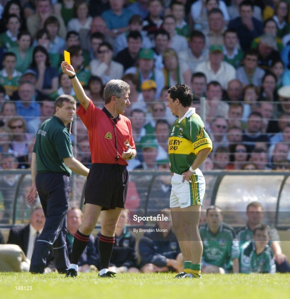 18 July 2004; Paul Galvin, Kerry, is shown the yellow card by referee Mick Curley, as Limerick manager Liam Kearns looks on. Bank of Ireland Munster Senior Football Championship Final Replay, Kerry v Limerick, Fitzgerald Stadium, Killarney, Co. Kerry. Picture credit; Brendan Moran / SPORTSFILE