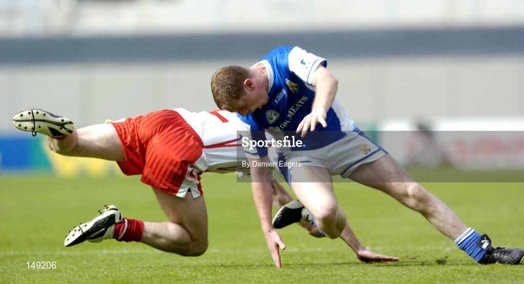 1 August 2004; Brian McDonald, Laois, and Ryan McMenamin, Tyrone, slip as they both race for possession. McDonald was taken off with a suspected broken right leg. Bank of Ireland All-Ireland Football Championship, Round 4, Laois v Tyrone, Croke Park, Dublin. Picture credit; Damien Eagers / SPORTSFILE