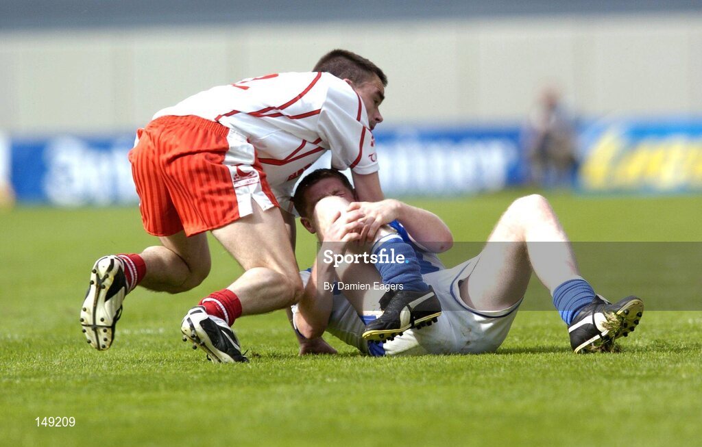 1 August 2004; Brian McDonald, Laois, and Ryan McMenamin, Tyrone, slip as they both race for possession. McDonald was taken off with a suspected broken right leg. Bank of Ireland All-Ireland Football Championship, Round 4, Laois v Tyrone, Croke Park, Dublin. Picture credit; Damien Eagers / SPORTSFILE