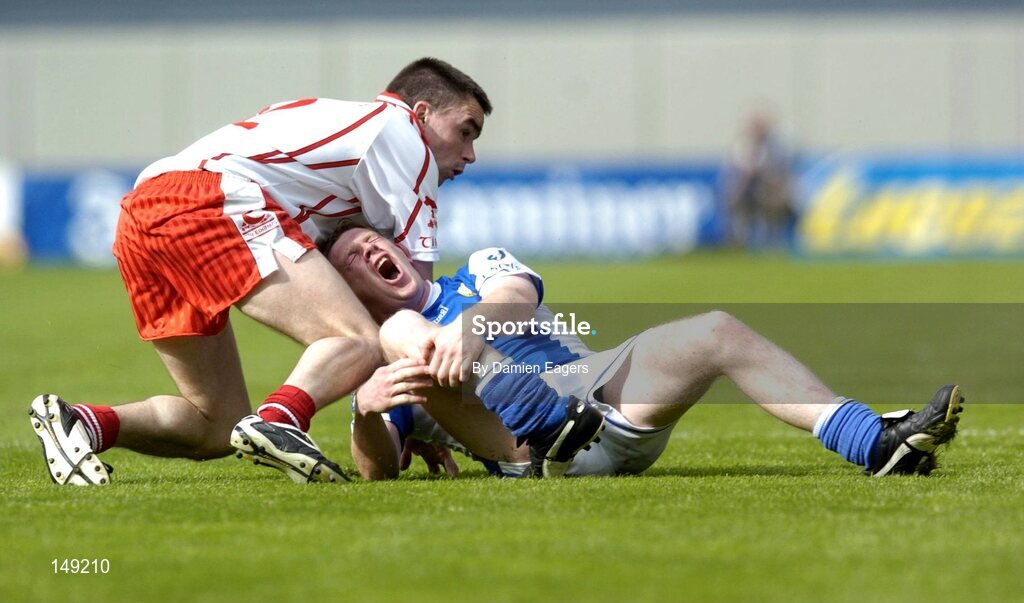 1 August 2004; Brian McDonald, Laois, and Ryan McMenamin, Tyrone, slip as they both race for possession. McDonald was taken off with a suspected broken right leg. Bank of Ireland All-Ireland Football Championship, Round 4, Laois v Tyrone, Croke Park, Dublin. Picture cr