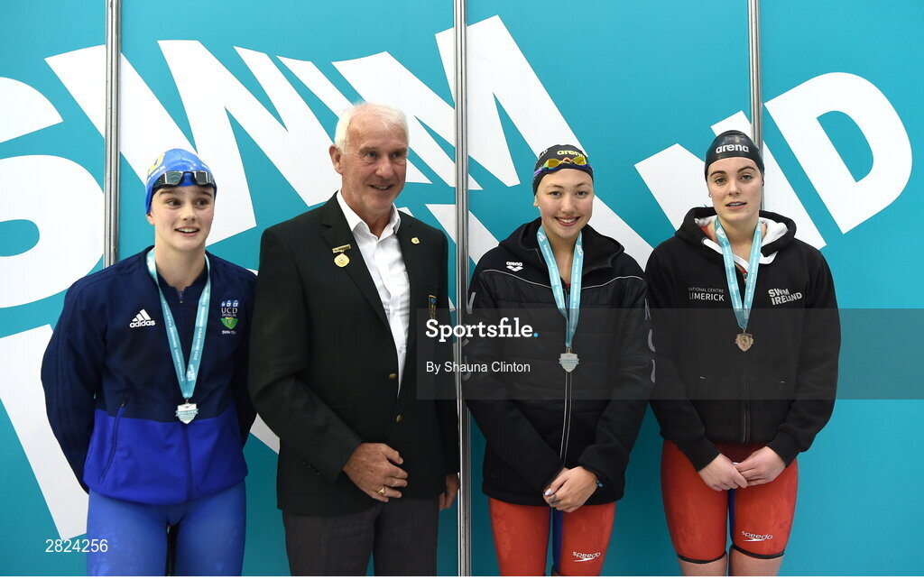 23 May 2024; Lottie Cullen of Nat Centre Uster Swim Belfast, third from left, who won gold, with Jenna Macdougald of UCD, left, who won silver, and Maria Godden of Kilkenny Swimming Club, right, who won bronze, after competing in the Women's 100m Backstroke Super Final, with Declan Harte, President of Swim Ireland, during day two of the Ireland Olympic Swimming Trials at the National Aquatic Centre on the Sport Ireland Campus in Dublin. Photo by Shauna Clinton/Sportsfile