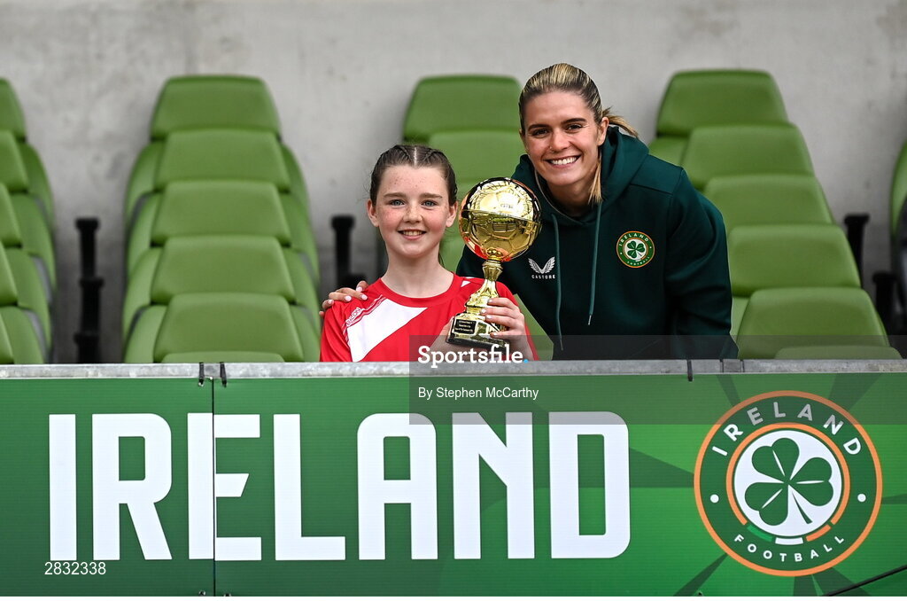 29 May 2024; Roise Walsh of Gurrane NS, Cork, is presented with the Player of the Tournament award for girls section A cup, for small sized schools, by Republic of Ireland's Jamie Finn during the FAI Primary 5s Finals day at Aviva Stadium in Dublin. Photo by Stephen McCarthy/Sportsfile
