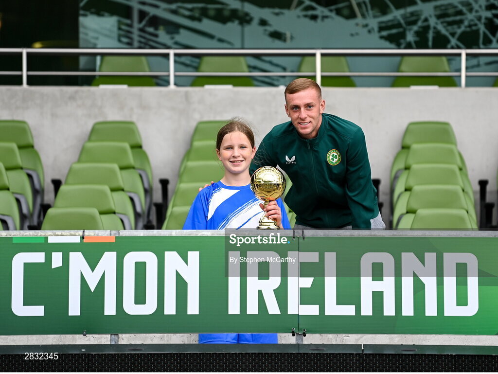 29 May 2024; Mia Whelan of Marshalstown NS, Wexford, is presented with the Player of the Tournament award for the girls section B cup, for medium schools, by Republic of Ireland U21 player Killian Phillips during the FAI Primary 5s Finals day at Aviva Stadium in Dublin. Photo by Stephen McCarthy/Sportsfile