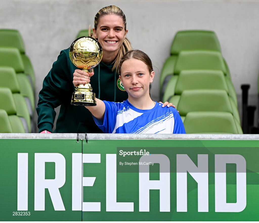29 May 2024; Hattie Farrell of Our Lady’s Grove PS, Dublin, is presented with the girls section C cup, for large sized schools, Player of the Tournament award by Republic of Ireland's Jamie Finn during the FAI Primary 5s Finals day at Aviva Stadium in Dublin. Photo by Stephen McCarthy/Sportsfile