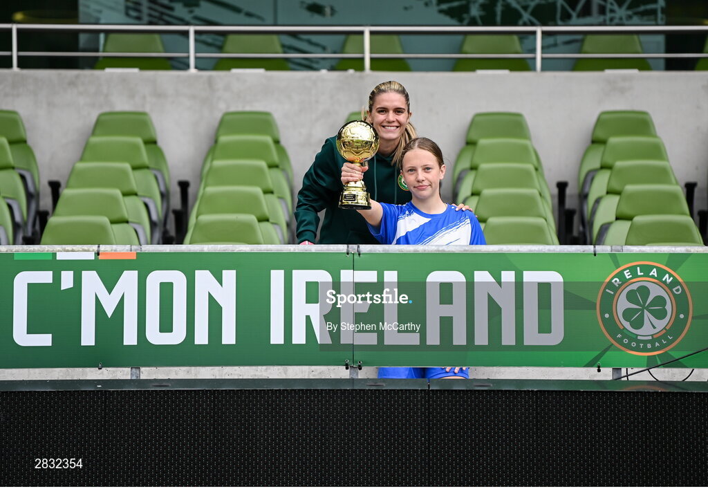 29 May 2024; Hattie Farrell of Our Lady’s Grove PS, Dublin, is presented with the girls section C cup, for large sized schools, Player of the Tournament award by Republic of Ireland's Jamie Finn during the FAI Primary 5s Finals day at Aviva Stadium in Dublin. Photo by Stephen McCarthy/Sportsfile