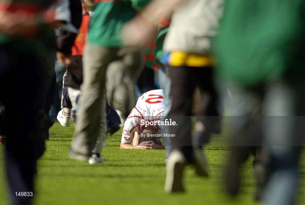 7 August 2004; A dejected Ryan McMenamin, Tyrone, as Mayo supporters envade the pitch to celebrate. Bank of Ireland All-Ireland Senior Football Championship Quarter Final, Mayo v Tyrone, Croke Park, Dublin. Picture credit; Brendan Moran / SPORTSFILE