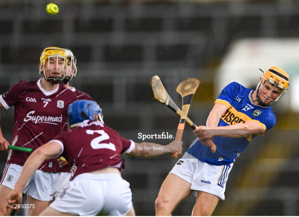 15 June 2024; Eoghan Doughan of Tipperary scores a point despite the attempted block of Cathal Maloney of Galway during the Electric Ireland GAA Hurling All-Ireland Minor Hurling Championship semi-final match between Tipperary and Galway at TUS Gaelic Grounds in Limerick. Photo by Tom Beary/Sportsfile