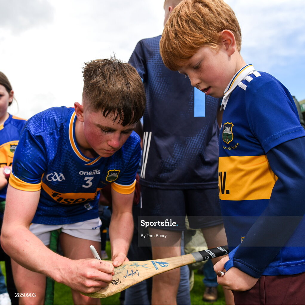 15 June 2024; Cathal O'Reilly of Tipperary signs the hurl of a young supporter after the Electric Ireland GAA Hurling All-Ireland Minor Hurling Championship semi-final match between Tipperary and Galway at TUS Gaelic Grounds in Limerick. Photo by Tom Beary/Sportsfile