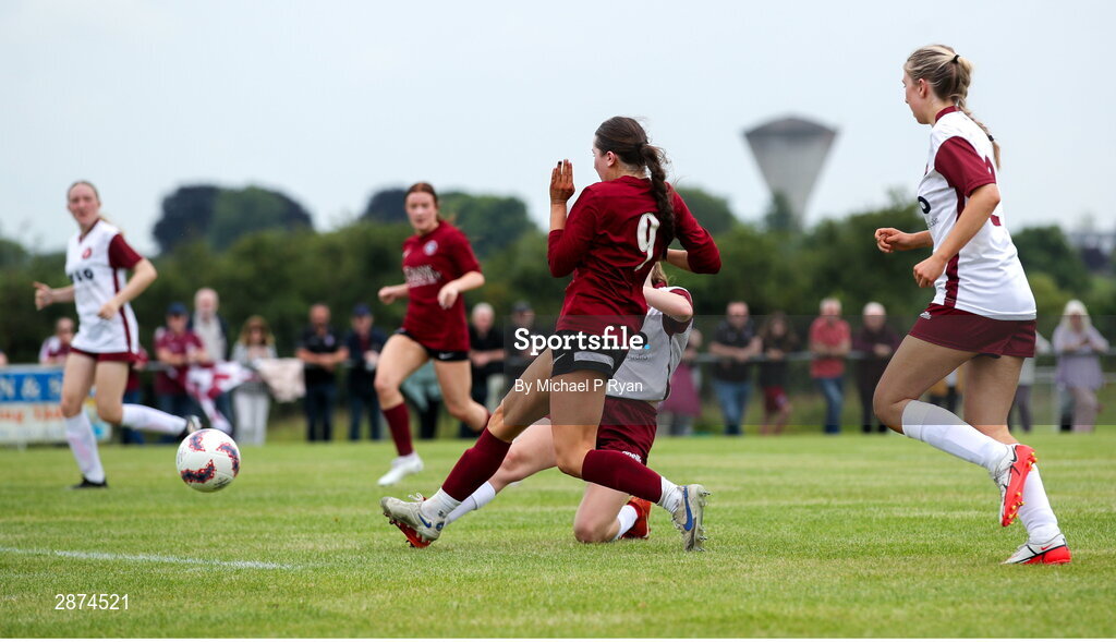 14 July 2024; Kerri O'Driscoll of Athenry shoots to score her side's second goal despite the attention of Drew Hendrick of Killester Donnycarney FC during the FAI Women's Under 17 Cup final match between Athenry and Killester Donnycarney FC at Mullingar Athletic FC in Gainstown, Westmeath. Photo by Michael P Ryan/Sportsfile