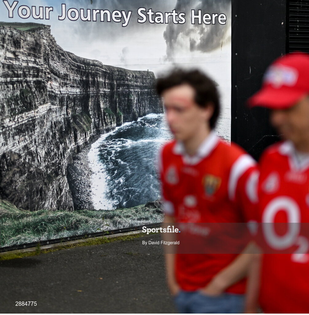 21 July 2024; Cork supporters walk past a photo of the Cliffs of Moher before the GAA Hurling All-Ireland Senior Championship Final between Clare and Cork at Croke Park in Dublin. Photo by David Fitzgerald/Sportsfile