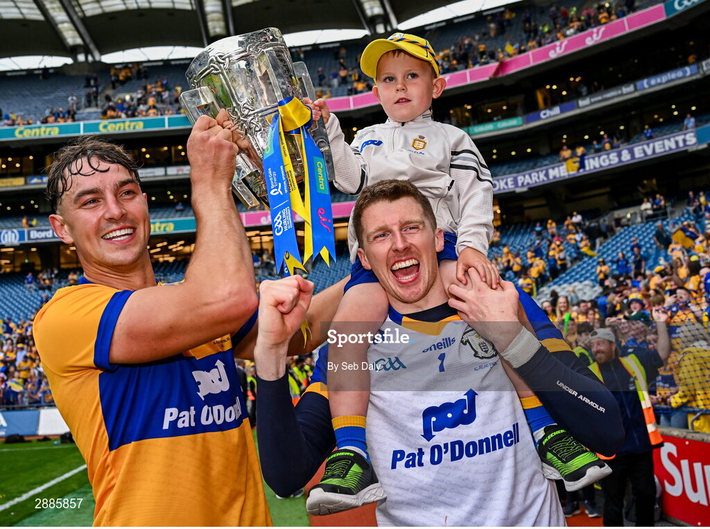 21 July 2024; Clare goalkeeper Eibhear Quilligan, right, with cousin Tadhg Ward, age five, and teammate Peter Duggan celebrate with the Liam MacCarthy Cup after their side's victory in during the GAA Hurling All-Ireland Senior Championship Final match between Clare and Cork at Croke Park in Dublin. Photo by Seb Daly/Sportsfile