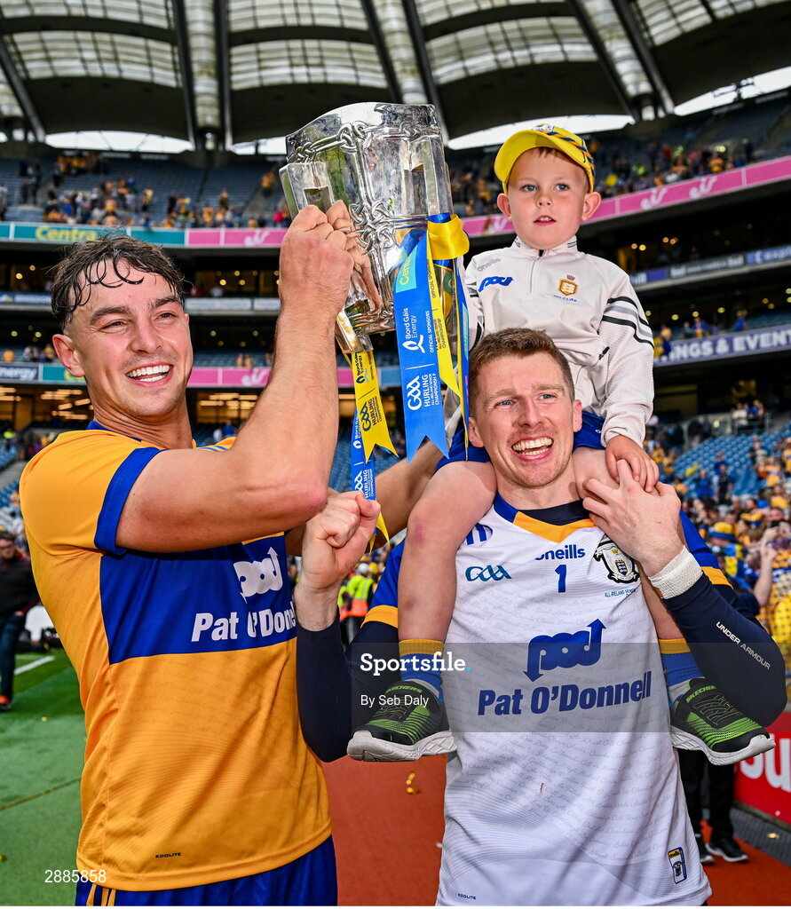 21 July 2024; Clare goalkeeper Eibhear Quilligan, right, with cousin Tadhg Ward, age five, and teammate Peter Duggan celebrate with the Liam MacCarthy Cup after their side's victory in during the GAA Hurling All-Ireland Senior Championship Final match between Clare and Cork at Croke Park in Dublin. Photo by Seb Daly/Sportsfile