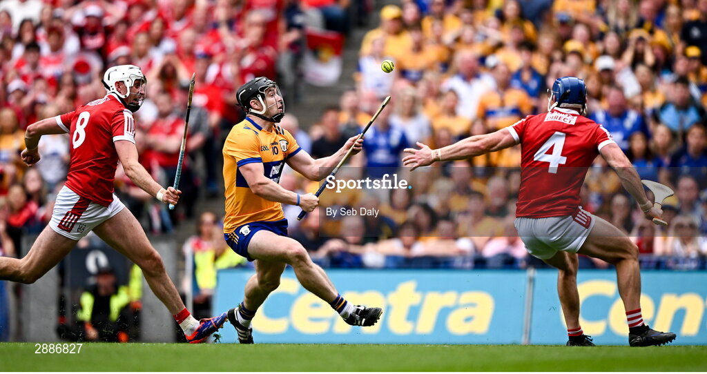 21 July 2024; Tony Kelly of Clare evades the tackle of Cork's Seán O'Donoghue, right, on his way to scoring his side's third goal during the GAA Hurling All-Ireland Senior Championship Final match between Clare and Cork at Croke Park in Dublin. Photo by Seb Daly/Sportsfile