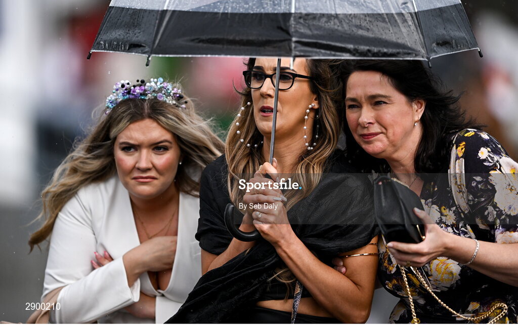 31 July 2024; Racegoers attempt to shelter from the rain during day three of the Galway Races Summer Festival at Ballybrit Racecourse in Galway. Photo by Seb Daly/Sportsfile