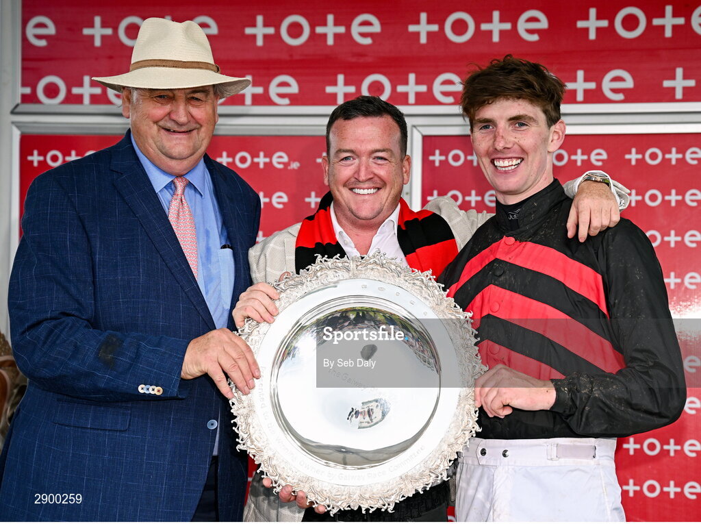 31 July 2024; Trainer Noel Meade, left, owner Philip Polly, centre, and jockey Donagh Meyler celebrate with the trophy after sending out Pinkerton to win the Tote Galway Plate during day three of the Galway Races Summer Festival at Ballybrit Racecourse in Galway. Photo by Seb Daly/Sportsfile