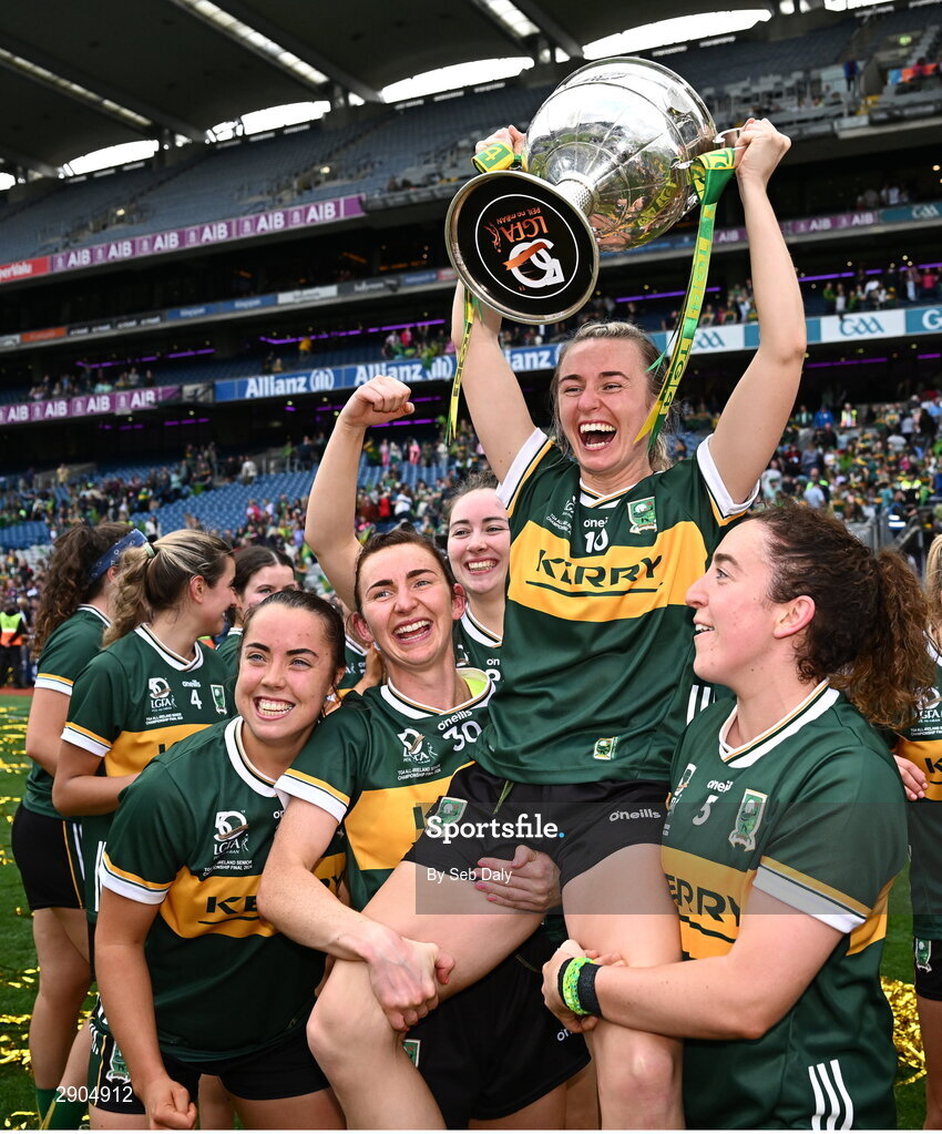 4 August 2024; Kerry captain Niamh Carmody celebrates with the the Brendan Martin cup as she is lifted up by teammates Cáit Lynch, left, and Kayleigh Cronin after their side's victory in the TG4 All-Ireland Ladies Football Senior Championship final match between Galway and Kerry at Croke Park, Dublin. Photo by Seb Daly/Sportsfile