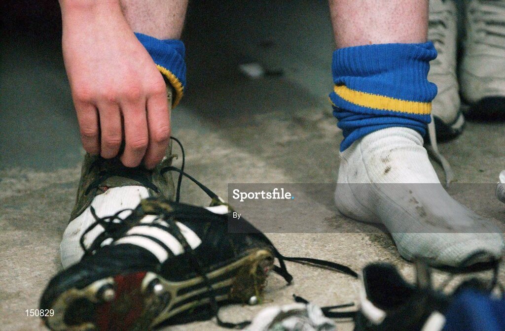 30 October 2002; A Member of the Longford Football team takes his boots off at the end of squad training. Longford Slashers GAA Club, Longford. Picture credit; David Maher / SPORTSFILE