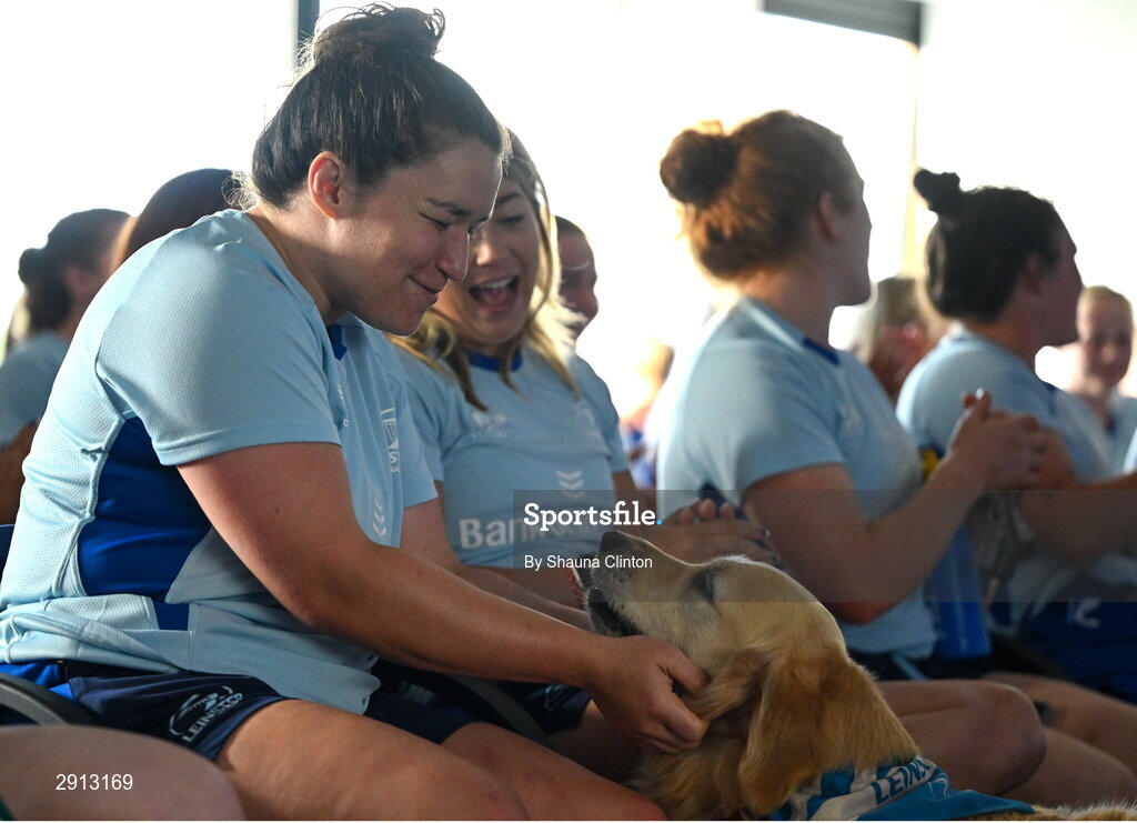 9 August 2024; Christy Haney, left, and Ailsa Hughes pet TJ the Dog during the Leinster Rugby women's jersey presentation at Energia Park in Dublin. Photo by Shauna Clinton/Sportsfile