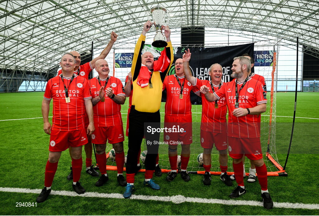 14 September 2024; Tony Hatton of Shelbourne lifts the cup with team-mates after their sie's victory at the League of Ireland Walking Football Festival 2024 at the National Sports Indoor Centre in Dublin. Photo by Shauna Clinton/Sportsfile