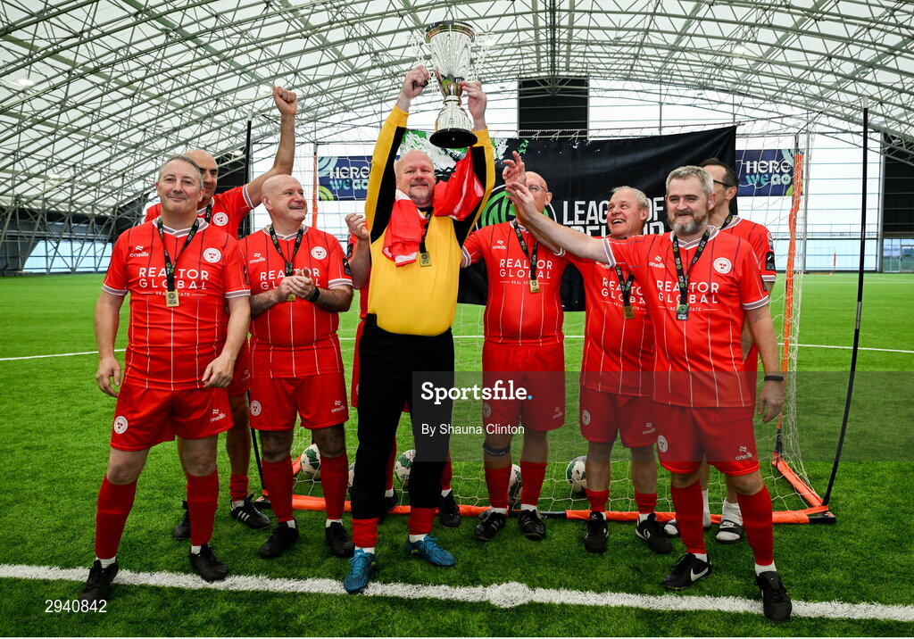 14 September 2024; Tony Hatton of Shelbourne lifts the cup with team-mates after their sie's victory at the League of Ireland Walking Football Festival 2024 at the National Sports Indoor Centre in Dublin. Photo by Shauna Clinton/Sportsfile