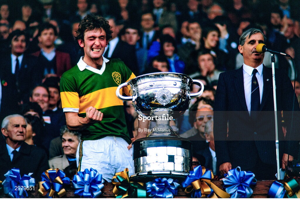 23 September 1984; Kerry captain Ambrose O'Donovan, in the company of GAA President Paddy Buggy, winks as he prepares to lift the Sam Maguire cup on the podium after their side's victory in the GAA All-Ireland Senior Football Championship final between Kerry and Dublin at Croke Park in Dublin. Photo by Ray McManus/Sportsfile