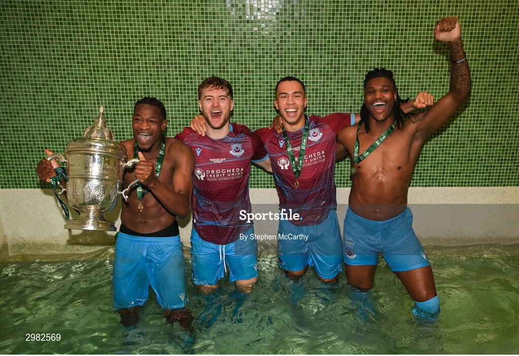 10 November 2024; Drogheda United players, from left, Elicha Ahui, Andrew Quinn, Douglas James-Taylor and Aaron Harper Bailey celebrate with the FAI cup in the dressingroom after the Sports Direct Men's FAI Cup Final match between Drogheda United and Derry City at the Aviva Stadium in Dublin. Photo by Stephen McCarthy/Sportsfile