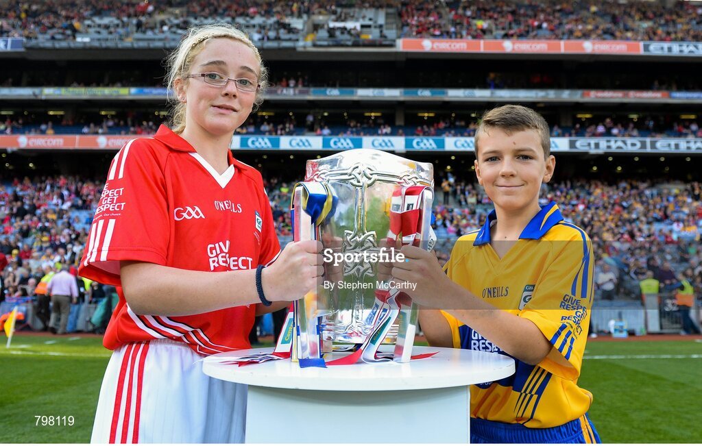 28 September 2013; Barry Morrissey, Clarecastle NS, Co. Clare, and Aine O'Regan, Scoil Bhailenora, Ballinora, Co. Cork. bring out Liam MacCarthy cup. GAA Hurling All-Ireland Senior Championship Final Replay, Cork v Clare, Croke Park, Dublin. Picture credit: Stephen McCarthy / SPORTSFILE