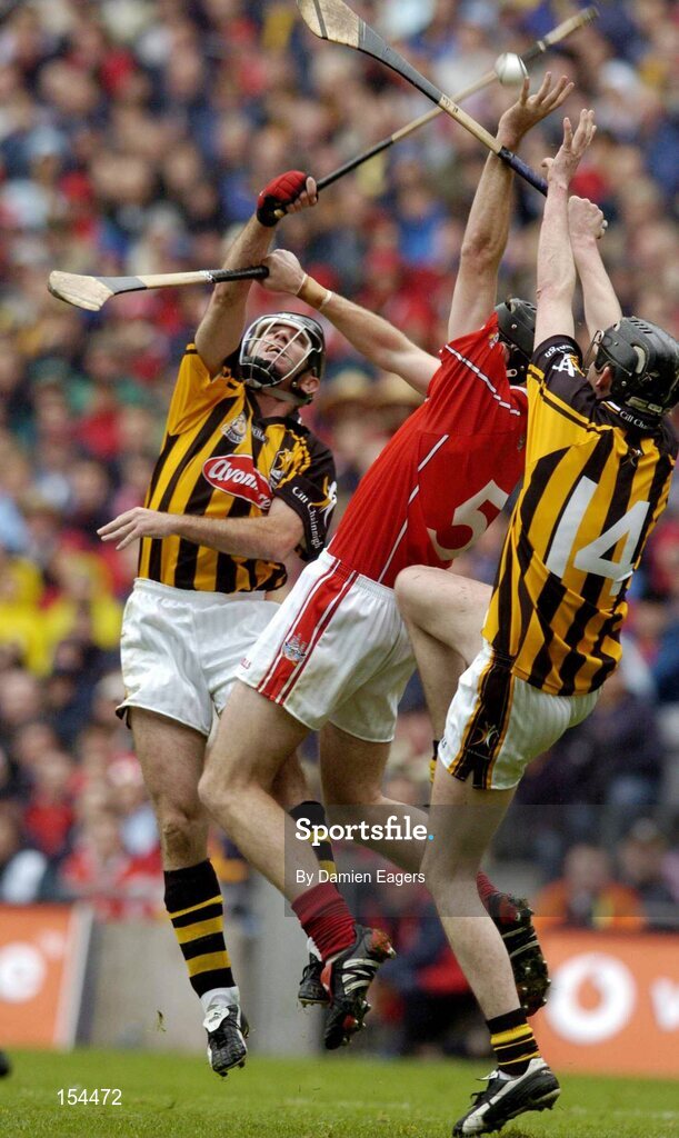 12 September 2004; John Gardiner, Cork, in action against D.J. Carey and Martin Comerford, (14), Kilkenny. Guinness All-Ireland Senior Hurling Championship Final, Cork v Kilkenny, Croke Park, Dublin. Picture credit; Damien Eagers / SPORTSFILE *** Local Caption *** Any photograph taken by SPORTSFILE during, or in connection with, the 2004 Guinness All-Ireland Hurling Final which displays GAA logos or contains an image or part of an image of any GAA intellectual property, or, which contains images of a GAA player/players in their playing uniforms, may only be used for editorial and non-advertising purposes.  Use of photographs for advertising, as posters or for purchase separately is strictly prohibited unless prior written approval has been obtained from the Gaelic Athletic Association.