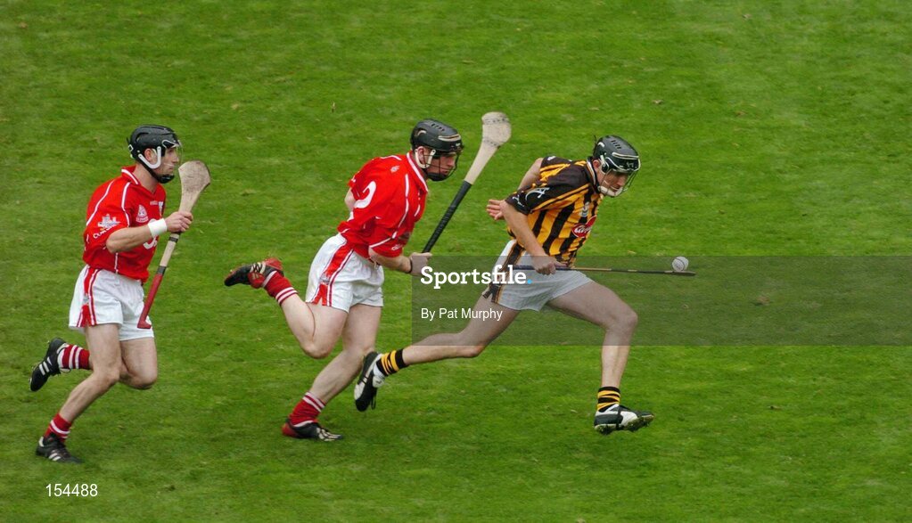 12 September 2004; Eddie Brennan, Kilkenny, in action against Wayne Sherlock and Ben O'Connor, left, Cork. Guinness All-Ireland Senior Hurling Championship Final, Cork v Kilkenny, Croke Park, Dublin. Picture credit; Pat Murphy / SPORTSFILE *** Local Caption *** Any photograph taken by SPORTSFILE during, or in connection with, the 2004 Guinness All-Ireland Hurling Final which displays GAA logos or contains an image or part of an image of any GAA intellectual property, or, which contains images of a GAA player/players in their playing uniforms, may only be used for editorial and non-advertising purposes.  Use of photographs for advertising, as posters or for purchase separately is strictly prohibited unless prior written approval has been obtained from the Gaelic Athletic Association.
