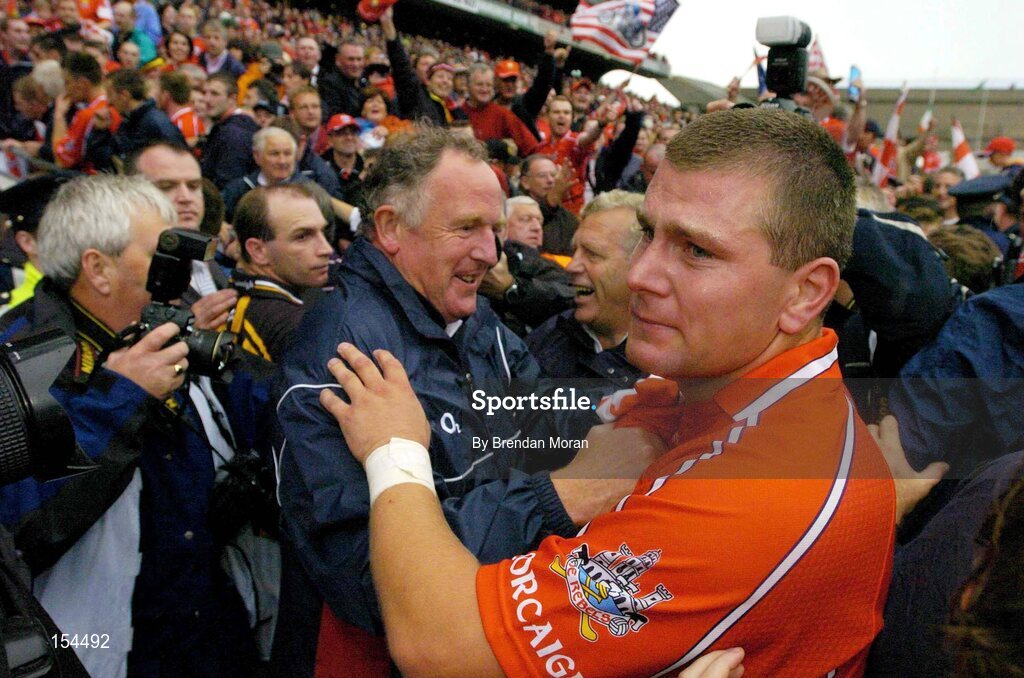 12 September 2004; Cork's Diarmuid O'Sullivan celebrates with team-doctor Dr. Con Murphy, centre, as Kilkenny's DJ Carey looks on. Guinness All-Ireland Senior Hurling Championship Final, Cork v Kilkenny, Croke Park, Dublin. Picture credit; Brendan Moran / SPORTSFILE *** Local Caption *** Any photograph taken by SPORTSFILE during, or in connection with, the 2004 Guinness All-Ireland Hurling Final which displays GAA logos or contains an image or part of an image of any GAA intellectual property, or, which contains images of a GAA player/players in their playing uniforms, may only be used for editorial and non-advertising purposes.  Use of photographs for advertising, as posters or for purchase separately is strictly prohibited unless prior written approval has been obtained from the Gaelic Athletic Association.
