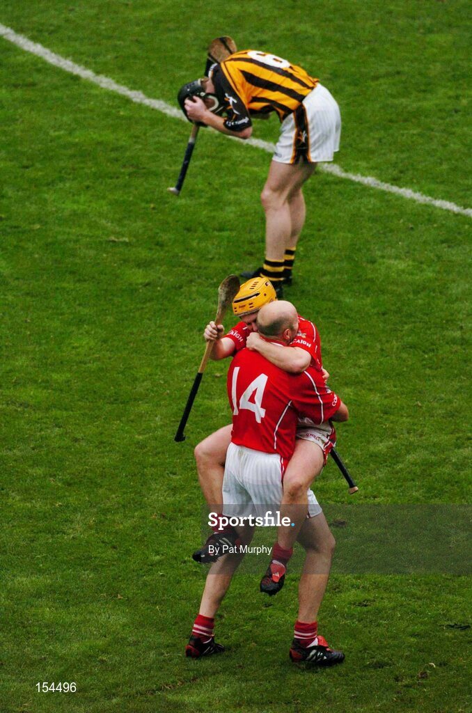 12 September 2004; Cork team-mates Brian Corcoran, 14, and Joe Deane celebrate at the final whistle as Kilkenny's Peter Barry shows his dissapointment. Guinness All-Ireland Senior Hurling Championship Final, Cork v Kilkenny, Croke Park, Dublin. Picture credit; Pat Murphy / SPORTSFILE *** Local Caption *** Any photograph taken by SPORTSFILE during, or in connection with, the 2004 Guinness All-Ireland Hurling Final which displays GAA logos or contains an image or part of an image of any GAA intellectual property, or, which contains images of a GAA player/players in their playing uniforms, may only be used for editorial and non-advertising purposes.  Use of photographs for advertising, as posters or for purchase separately is strictly prohibited unless prior written approval has been obtained from the Gaelic Athletic Association.