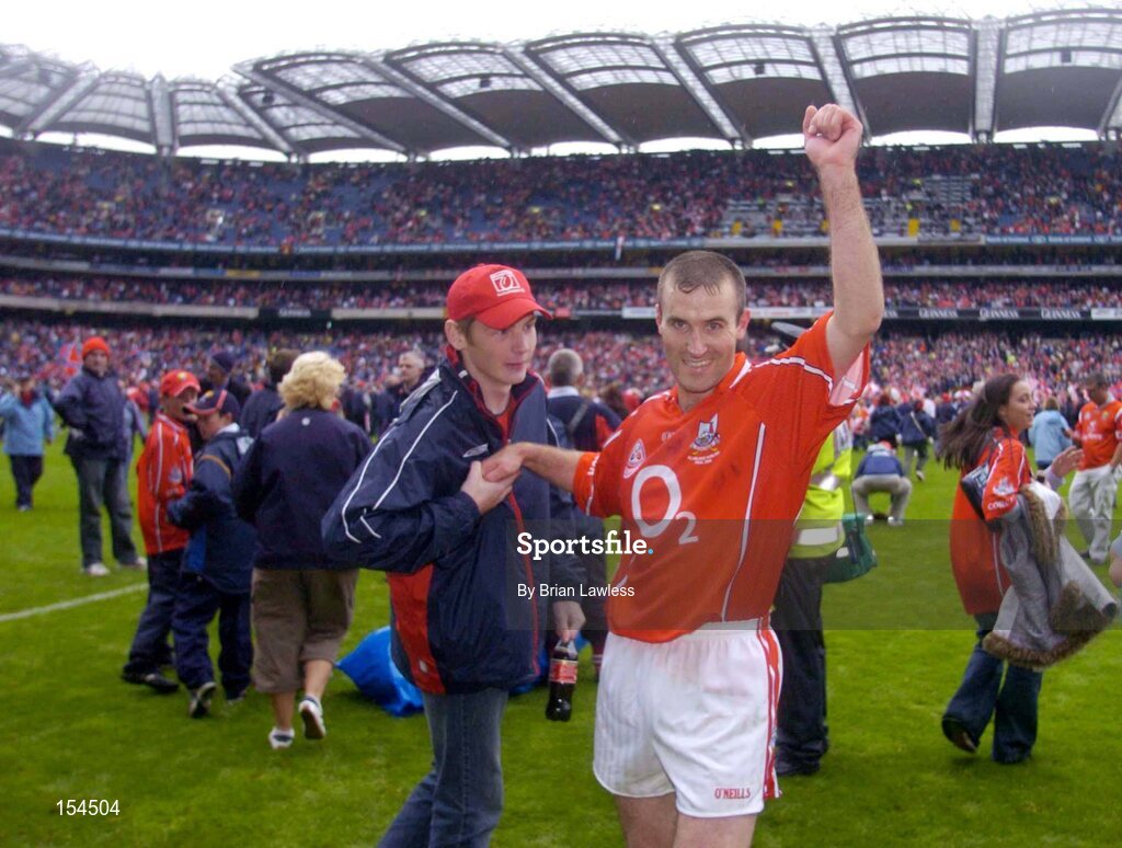 12 September 2004; Cork's Jerry O'Connor celebrates with a fan after victory over Kilkenny. Guinness All-Ireland Senior Hurling Championship Final, Cork v Kilkenny, Croke Park, Dublin. Picture credit; Brian Lawless / SPORTSFILE *** Local Caption *** Any photograph taken by SPORTSFILE during, or in connection with, the 2004 Guinness All-Ireland Hurling Final which displays GAA logos or contains an image or part of an image of any GAA intellectual property, or, which contains images of a GAA player/players in their playing uniforms, may only be used for editorial and non-advertising purposes.  Use of photographs for advertising, as posters or for purchase separately is strictly prohibited unless prior written approval has been obtained from the Gaelic Athletic Association.