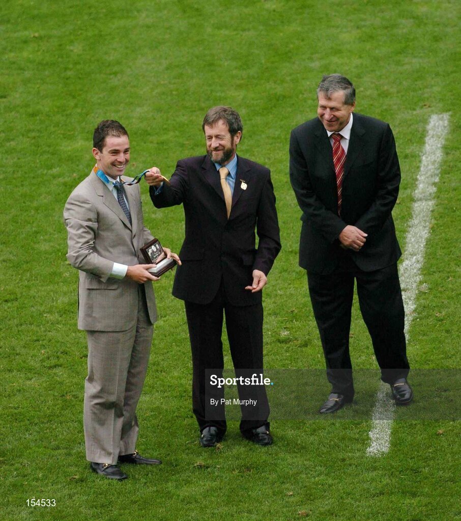 12 September 2004; Sean Kelly, GAA President, with Ard Stuirthoir of the GAA Liam Mulvihill, right, shows off the Olympic gold medal won by Cian O'Connor, left. Guinness All-Ireland Senior Hurling Championship Final, Cork v Kilkenny, Croke Park, Dublin. Picture credit; Pat Murphy / SPORTSFILE *** Local Caption *** Any photograph taken by SPORTSFILE during, or in connection with, the 2004 Guinness All-Ireland Hurling Final which displays GAA logos or contains an image or part of an image of any GAA intellectual property, or, which contains images of a GAA player/players in their playing uniforms, may only be used for editorial and non-advertising purposes.  Use of photographs for advertising, as posters or for purchase separately is strictly prohibited unless prior written approval has been obtained from the Gaelic Athletic Association.