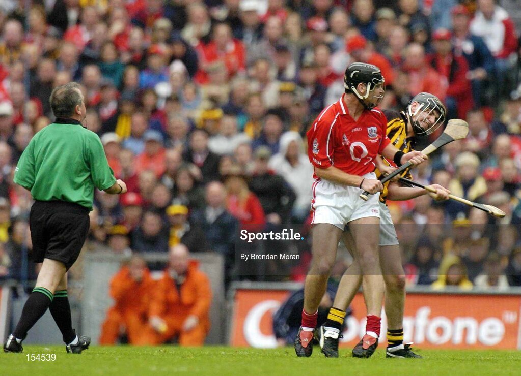 12 September 2004; Ronan Curran, Cork, and John Hoyne, Kilkenny, clash in sight of referee Aodan MacSuibhne. Guinness All-Ireland Senior Hurling Championship Final, Cork v Kilkenny, Croke Park, Dublin. Picture credit; Brendan Moran / SPORTSFILE *** Local Caption *** Any photograph taken by SPORTSFILE during, or in connection with, the 2004 Guinness All-Ireland Hurling Final which displays GAA logos or contains an image or part of an image of any GAA intellectual property, or, which contains images of a GAA player/players in their playing uniforms, may only be used for editorial and non-advertising purposes.  Use of photographs for advertising, as posters or for purchase separately is strictly prohibited unless prior written approval has been obtained from the Gaelic Athletic Association.