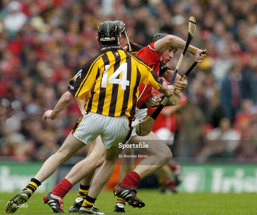 12 September 2004; John Gardiner, Cork, in action against John Hoyne (hidden) and Martin Comerford (14), Kilkenny. Guinness All-Ireland Senior Hurling Championship Final, Cork v Kilkenny, Croke Park, Dublin. Picture credit; Brendan Moran / SPORTSFILE *** Local Caption *** Any photograph taken by SPORTSFILE during, or in connection with, the 2004 Guinness All-Ireland Hurling Final which displays GAA logos or contains an image or part of an image of any GAA intellectual property, or, which contains images of a GAA player/players in their playing uniforms, may only be used for editorial and non-advertising purposes.  Use of photographs for advertising, as posters or for purchase separately is strictly prohibited unless prior written approval has been obtained from the Gaelic Athletic Association.