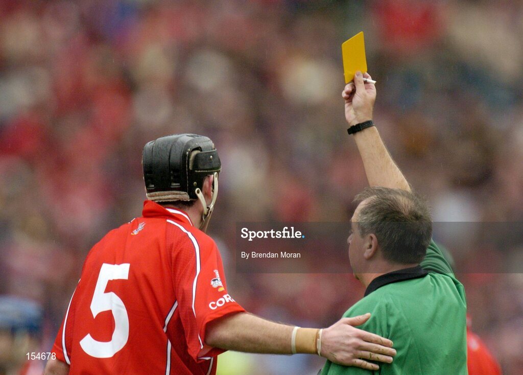 12 September 2004; John Gardiner, Cork, is shown a yellow card by referee Aodan MacSuibhne. Guinness All-Ireland Senior Hurling Championship Final, Cork v Kilkenny, Croke Park, Dublin. Picture credit; Brendan Moran / SPORTSFILE *** Local Caption *** Any photograph taken by SPORTSFILE during, or in connection with, the 2004 Guinness All-Ireland Hurling Final which displays GAA logos or contains an image or part of an image of any GAA intellectual property, or, which contains images of a GAA player/players in their playing uniforms, may only be used for editorial and non-advertising purposes.  Use of photographs for advertising, as posters or for purchase separately is strictly prohibited unless prior written approval has been obtained from the Gaelic Athletic Association.
