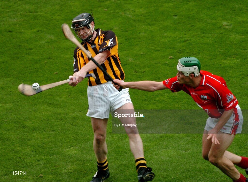 12 September 2004; Peter Barry, Kilkenny, clears under pressure from Niall McCarthy, Cork. Guinness All-Ireland Senior Hurling Championship Final, Cork v Kilkenny, Croke Park, Dublin. Picture credit; Pat Murphy / SPORTSFILE *** Local Caption *** Any photograph taken by SPORTSFILE during, or in connection with, the 2004 Guinness All-Ireland Hurling Final which displays GAA logos or contains an image or part of an image of any GAA intellectual property, or, which contains images of a GAA player/players in their playing uniforms, may only be used for editorial and non-advertising purposes.  Use of photographs for advertising, as posters or for purchase separately is strictly prohibited unless prior written approval has been obtained from the Gaelic Athletic Association.