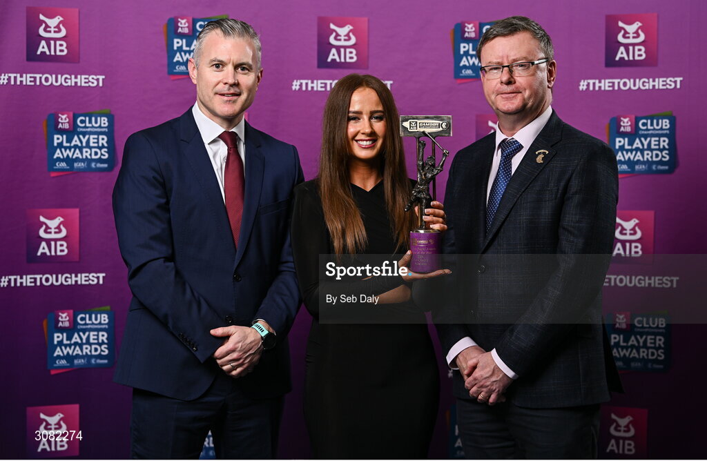 21 March 2025; Sarsfields camogie player Tara Kenny is presented her 2024 Camogie Team of the Year award by Uachtarán an Cumann Camógaíochta, Brian Molloy, right, and Chief Marketing Officer of AIB, Mark Doyle during the AIB Club Player Awards at Croke Park in Dublin. The AIB Club Player Awards celebrated the best players from club Football, Hurling, Camogie, and LGFA in a single ceremony for the first time, recognising their outstanding achievements on the field throughout the season. Photo by Seb Daly/Sportsfile