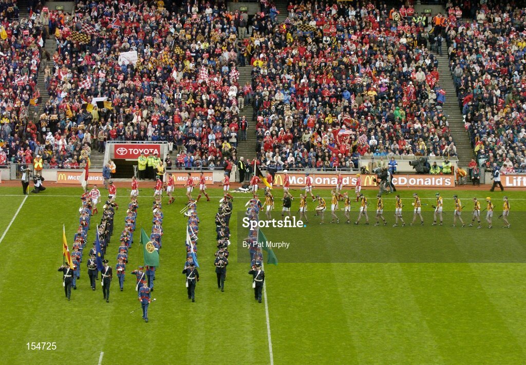 12 September 2004; The Cork and Kilkenny teams during the pre-match parade behind the Artane Boys Band. Guinness All-Ireland Senior Hurling Championship Final, Cork v Kilkenny, Croke Park, Dublin. Picture credit; Pat Murphy / SPORTSFILE *** Local Caption *** Any photograph taken by SPORTSFILE during, or in connection with, the 2004 Guinness All-Ireland Hurling Final which displays GAA logos or contains an image or part of an image of any GAA intellectual property, or, which contains images of a GAA player/players in their playing uniforms, may only be used for editorial and non-advertising purposes.  Use of photographs for advertising, as posters or for purchase separately is strictly prohibited unless prior written approval has been obtained from the Gaelic Athletic Association.