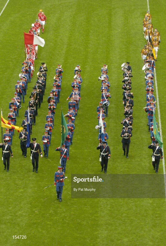 12 September 2004; The Cork and Kilkenny teams during the pre-match parade behind the Atane Boys Band. Guinness All-Ireland Senior Hurling Championship Final, Cork v Kilkenny, Croke Park, Dublin. Picture credit; Pat Murphy / SPORTSFILE *** Local Caption *** Any photograph taken by SPORTSFILE during, or in connection with, the 2004 Guinness All-Ireland Hurling Final which displays GAA logos or contains an image or part of an image of any GAA intellectual property, or, which contains images of a GAA player/players in their playing uniforms, may only be used for editorial and non-advertising purposes.  Use of photographs for advertising, as posters or for purchase separately is strictly prohibited unless prior written approval has been obtained from the Gaelic Athletic Association.
