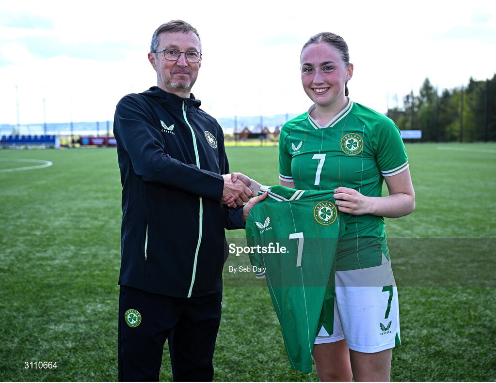 17 April 2025; Halle Harcourt of Republic of Ireland is presented with her jersey by Republic of Ireland head coach Richard Berkeley after the Girls U15 SAFIB Bob Docherty Cup match between Northern Ireland and Republic of Ireland at Greenisland FC in Antrim. Photo by Seb Daly/Sportsfile