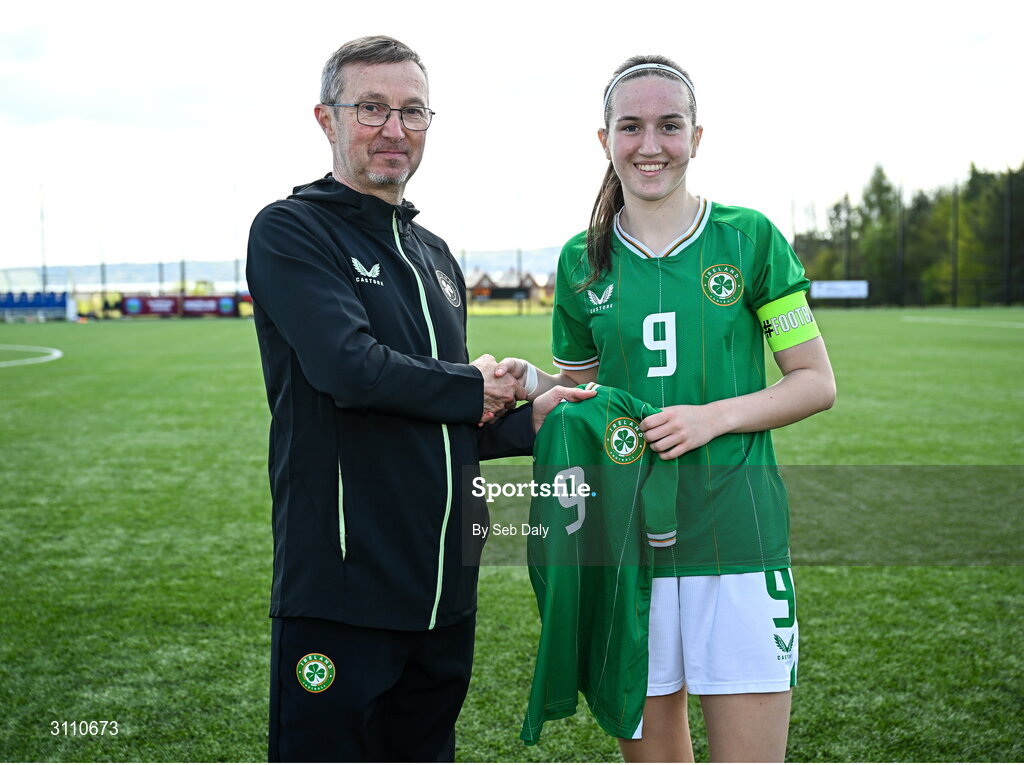 17 April 2025; Ciara Milton of Republic of Ireland is presented with her jersey by Republic of Ireland head coach Richard Berkeley after the Girls U15 SAFIB Bob Docherty Cup match between Northern Ireland and Republic of Ireland at Greenisland FC in Antrim. Photo by Seb Daly/Sportsfile