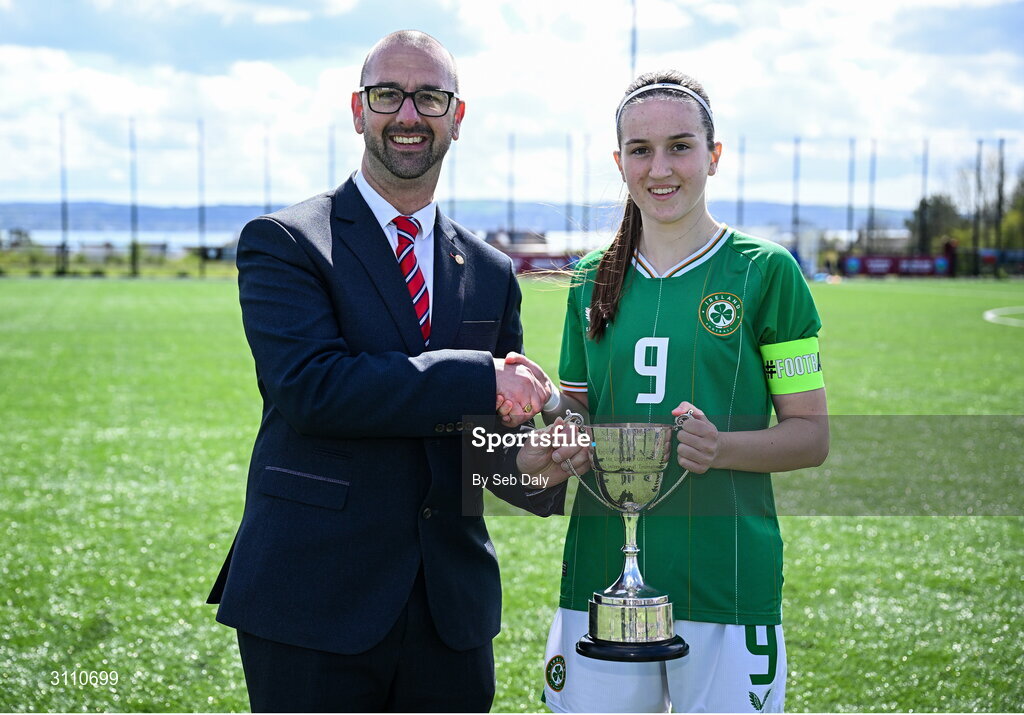 17 April 2025; Republic of Ireland captain Ciara Milton is presented with the Bob Docherty Cup by Schools' Association Football International Board chair Mark Hignett after  the Girls U15 SAFIB Bob Docherty Cup match between Northern Ireland and Republic of Ireland at Greenisland FC in Antrim. Photo by Seb Daly/Sportsfile