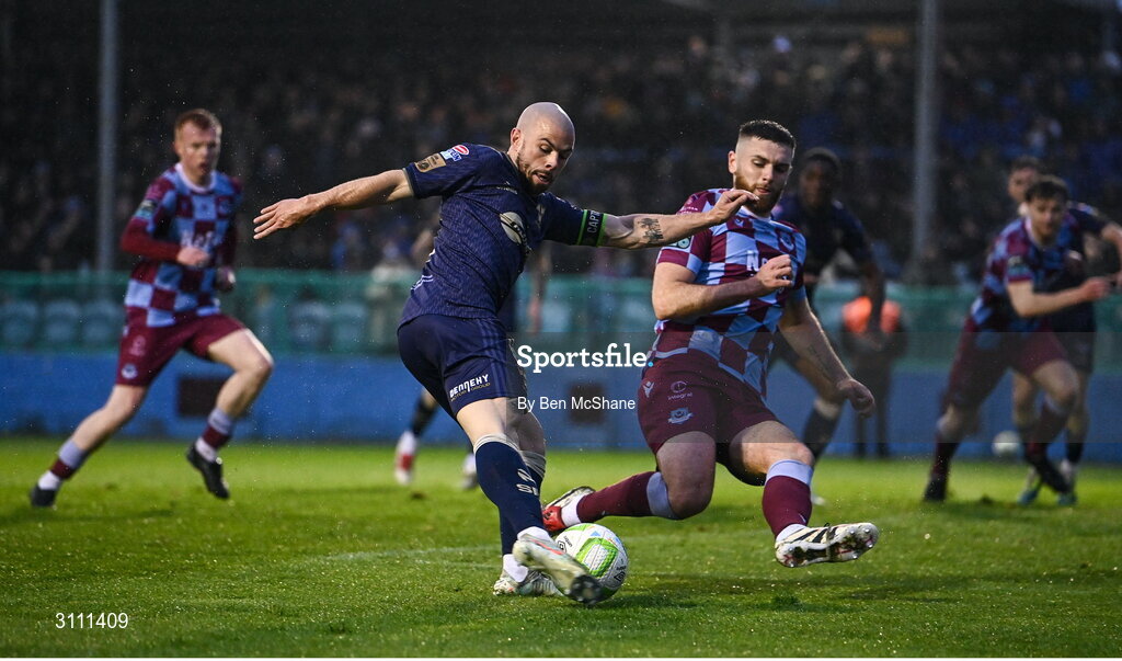 18 April 2025; Mark Coyle of Shelbourne shoots to score his side's first goal despite the efforts of Conor Keeley of Drogheda United during the SSE Airtricity Men's Premier Division match between Drogheda United and Shelbourne at Sullivan & Lambe Park in Drogheda, Louth. Photo by Ben McShane/Sportsfile