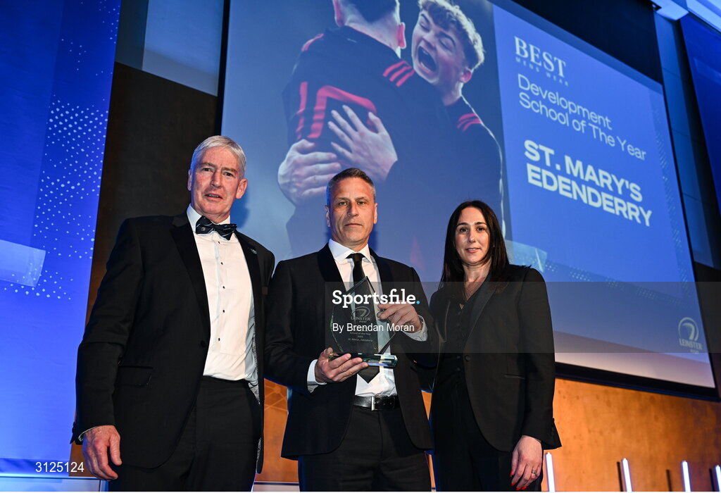 6 May 2025; Tom Rehill, representing St Mary's Edenderry in Offaly, is presented with the Best Menswear Development School Award by Best Menswear E-commerce Manager Lyndsey Clancy, right, and Leinster Rugby president Declan Gardiner during the Leinster Rugby awards ball 2025 at O'Reilly Hall in UCD, Dublin. Photo by Brendan Moran/Sportsfile