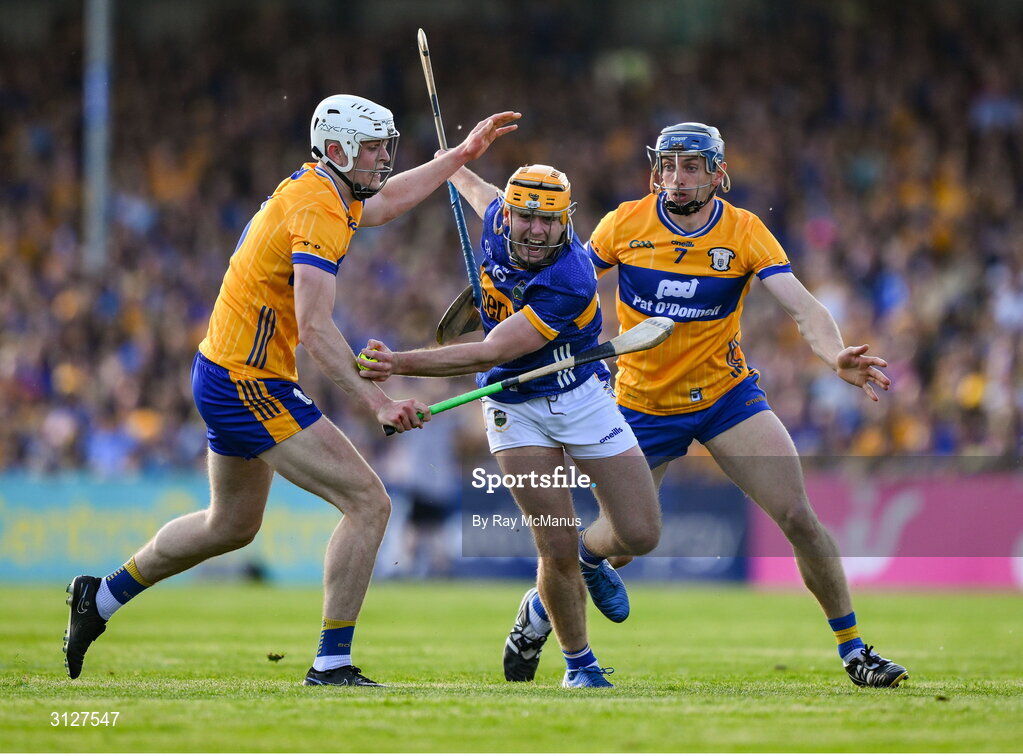 10 May 2025; Conor Stakelum of Tipperary is tackled by David McInerney, left, and Cian Galvin of Clare during the Munster GAA Hurling Senior Championship Round 3 match between Clare and Tipperary at Zimmer Biomet Páirc Chíosóg in Ennis, Clare. Photo by Ray McManus/Sportsfile