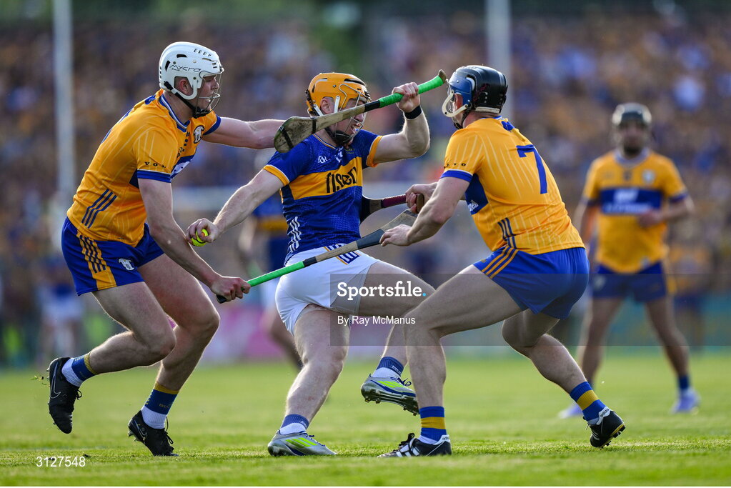 10 May 2025; Jake Morris of Tipperary is tackled by Cian Galvin and David McInerney of Clare during the Munster GAA Hurling Senior Championship Round 3 match between Clare and Tipperary at Zimmer Biomet Páirc Chíosóg in Ennis, Clare. Photo by Ray McManus/Sportsfile