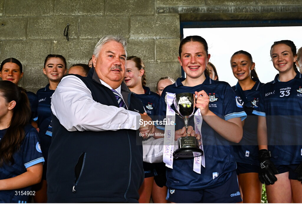 8 June 2025; Dublin captain  Maeve Conlon is presented with the trophy by LGFA Vice-President, Robbie Smyth, after the 2025 All-Ireland Ladies U14 Gold Final between Dublin and Kerry, at Nenagh Éire Óg GAA Club, Nenagh, Co. Tipperary. Photo by Tyler Miller/Sportsfile