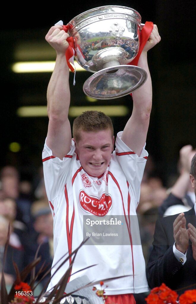 26 September 2004; Tyrone captain Marc Cunningham lifts the Tom Markham cup after victory over Kerry. All-Ireland Minor Football Championship Final, Kerry v Tyrone, Croke Park, Dublin. Picture credit; Brian Lawless / SPORTSFILE *** Local Caption *** Any photograph taken by SPORTSFILE during, or in connection with, the 2004 All-Ireland Minor Football Final which displays GAA logos or contains an image or part of an image of any GAA intellectual property, or, which contains images of a GAA player/players in their playing uniforms, may only be used for editorial and non-advertising purposes.  Use of photographs for advertising, as posters or for purchase separately is strictly prohibited unless prior written approval has been obtained from the Gaelic Athletic Association.