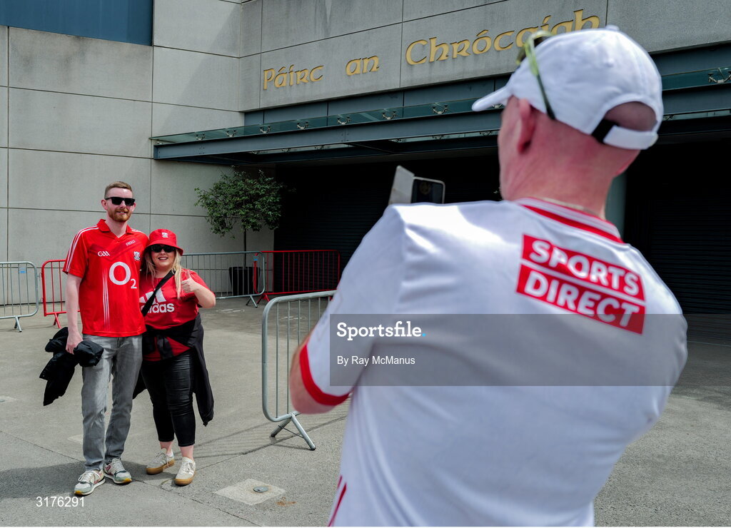 5 July 2025; Cork supporters Robert Murphy takes a photograph of  William McCarthy and Emma Jane Murphy, from Carrigaline, outside Croke Park before the GAA Hurling All-Ireland Senior Championship semi-final match between Cork and Dublin at Croke Park in Dublin. Photo by Ray McManus/Sportsfile